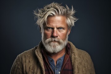 Portrait of a handsome senior man with grey beard and dyed hair.