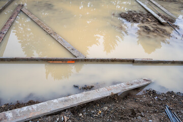 Under construction, residential house foundation dug out and framing started, flooded with...