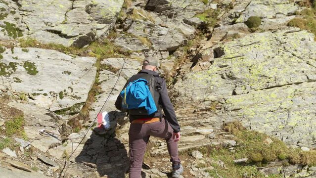 Male hiker climbs along GR path on mountainside, Italy
