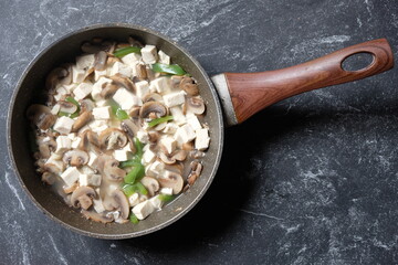 Tumis Tahu Jamur Kancing Paprika, saute tofu, champignon mushrooms, and green peppers in a marble skillet. Indonesian food. vegan menu. healthy food. 