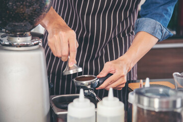 Close up hands coffee barista man make hot cup espresso shot from coffee machine. Cappuccino with milk in italian coffee shop cafe. Close up hands of barista use machine make black drinking hot cup