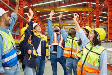 group of engineers and technicians raise hands for success work and project in the factory