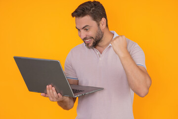 Excited business man working on laptop in studio. Man checking email on laptop, writing message in social network, using internet, searching information on laptops. Man using laptop computer.