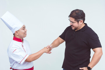 An asian chef shaking the hand of his boss or customer. Sign of agreement or gratitude. Isolated on a white background.