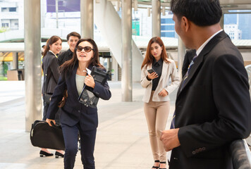 Women carrying a briefcase running in a hurry to go to work among the people walking