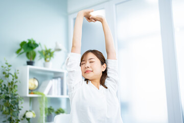 Fototapeta na wymiar 家でストレッチをする若い日本人女性