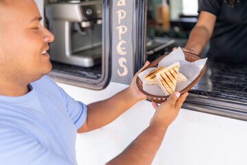 Happy client receiving a sandwich from a food truck