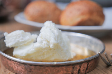 butter cream and honey in a bowl on table .