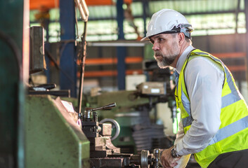Professional labor machanic engineer technician worker senior man industrial wearing safety uniform working control with heavy machine in manufacturing  factory production line.business industry