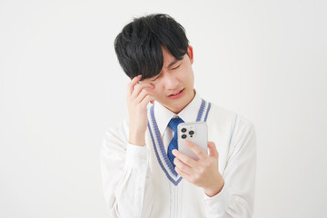 スマートフォンを持って考える男子高校生　白背景