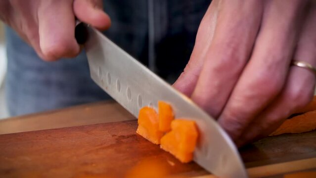 Person chopping carrots into slices 
