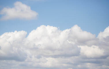 Naklejka na ściany i meble White large clouds against a blue sky.