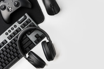 Top view of gamer table with computer keyboard, joystick and headphones