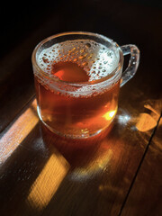 Black tea in a glass cup on a wooden table in the morning