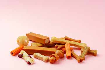 Dog chew bone and sticks on pink background