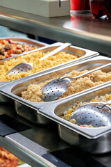 Metal trays with fresh food in a canteen
