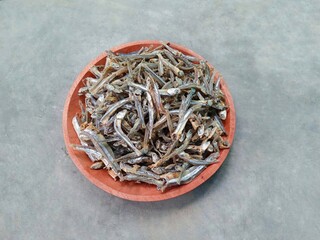 anchovies served on a wooden plate on a gray background. side dishes. salted fish.