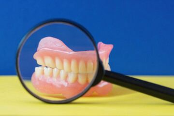 Dental examination.dental examination process.Bright yellow background and blue background.Teeth model and magnifying glass