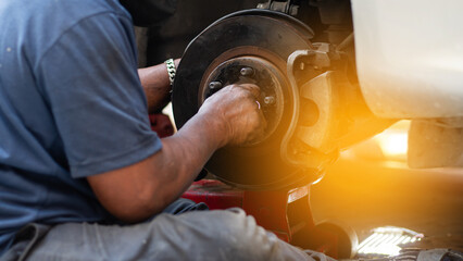 Mechanic using wrench while working on car engine at garage workshop, Car auto services and...
