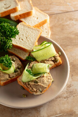 Open sandwiches with pate, cucumber, capers, and parsley.