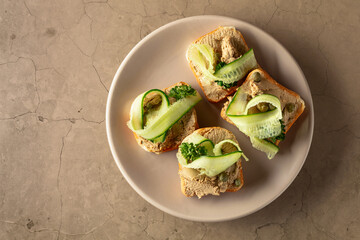 Toasts with pate on a beige stone background.