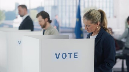 Portrait of a Beautiful Adult Woman Filling Out a Ballot in a Voting Booth on the Day of National Elections in the European Union. Diverse Men and Women Voting for Elected Officials in an EU Country