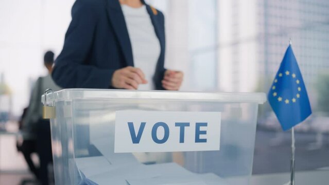 Democratic Process: Anonymous Europeans Visiting a Polling Station on Elections Day in the European Union. Female and Male Voters Casting Their Votes and Putting Ballots into a Transparent Sealed Box