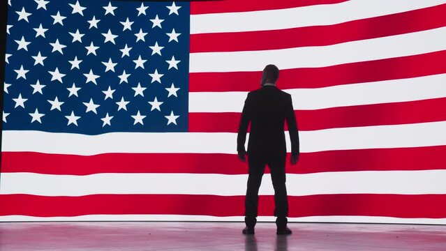 Independence, Liberty, Freedom in the United States of America Concept. Silhouette of a Proud Patriotic Adult Man Standing in Front of a Digital Screen with an Animated American Flag