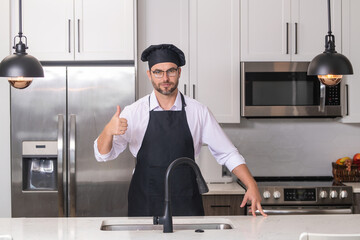 Handsome man chef in uniform cooking in the kitchen. Restaurant menu concept. Hispanic man in baker...