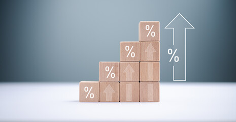 Increasing percentage sign symbol on growth wooden block stacking and arrow up for financial saving...