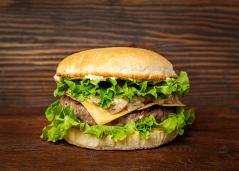 Burger, sandwich, hamburger with meat cutlet and cheese on a wooden background