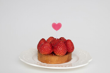 Concept for Valentine's day, 14 February Strawberry Tart pinned with Red Heart, white background