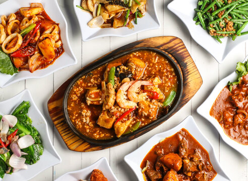 hot plate beancurd shrimp, dried shrimp fried french beans, ginger onion fish fillet, baby kailan or kai lan, sambal sotong, curry chicken, curry lamb ribs isolated on table top view of singapore food