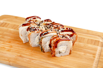 Japanese unagi sushi roll with eel on a wooden board, isolated.