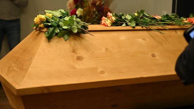 funeral concept. flowers on the coffin and an empty photo frame. overall plan. bereavement. death of a loved one.