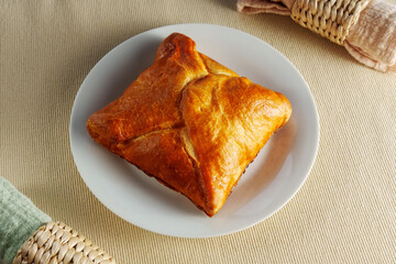 A visually stunning composition featuring a perfectly baked puff pastry adorning a pristine white plate.