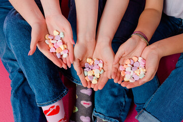 Hands holding candy hearts with blue jeans and valentine's day socks