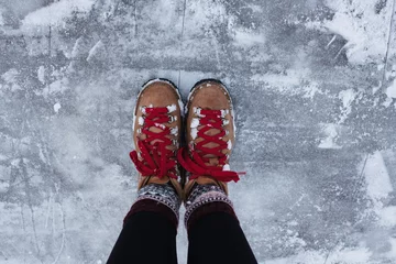 Foto op Canvas person stood with hiking boots on ice in winter © Cavan