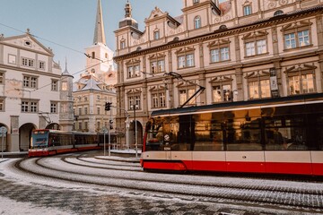 Snowy Prague, trams driving through a small square