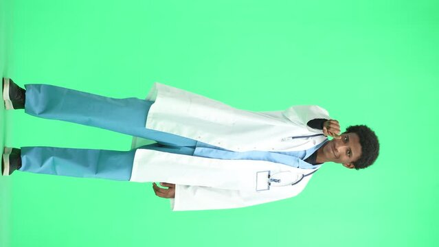 The doctor, in full height, on a green background, hits his chest