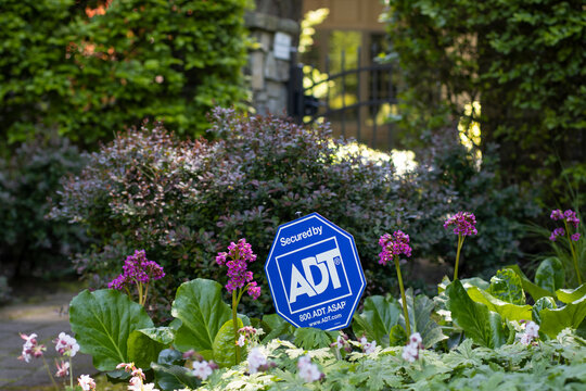 Lake Oswego, OR, USA - May 21, 2022: Secured by ADT sign is seen outside a gated property. ADT, Inc. is a security company that provides residential and small business electronic security services.