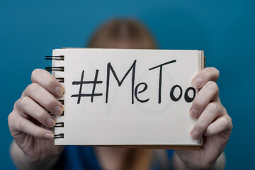 Kobieta trzyma kartkę z napisanym hasztagiem i słowami Me Too, problem molestowania kobiet