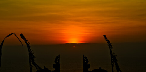 views of Penjor, Janur and Balinese temples with the sunset of Uluwatu, Bali