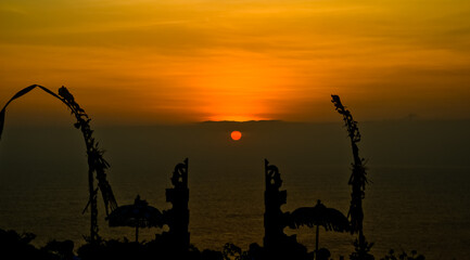 views of Penjor, Janur and Balinese temples with the sunset of Uluwatu, Bali