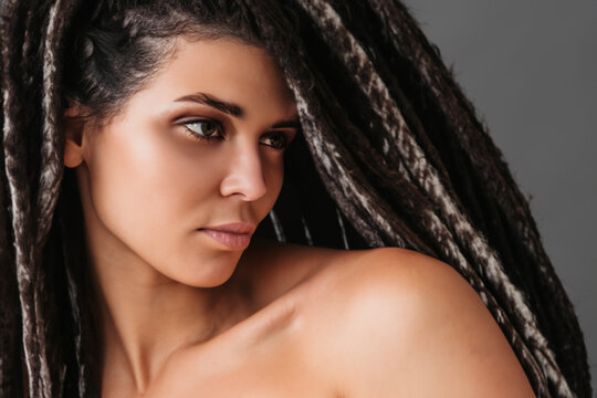 fashionable girl. a young girl with long black dreadlocks with white strands on her head, the girl stands in a model pose with bare shoulders
