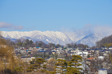 冬の松本市の街並みの風景と雪山の景色