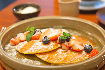 Top down view of delicious strawberry and blueberry pancakes on plate