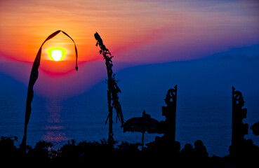 views of Penjor, Janur and Balinese temples with the sunset of Uluwatu, Bali