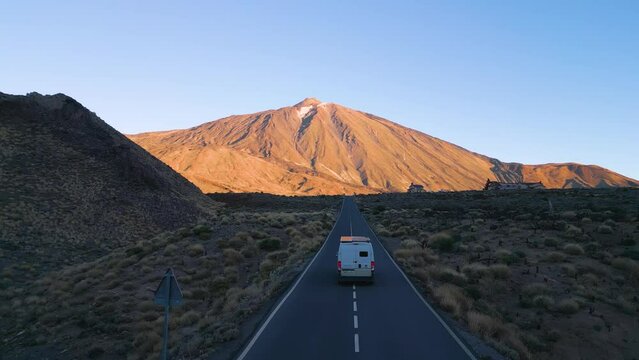Watch as a van smoothly drives down a scenic road, with the majestic Teide mountain in the backdrop on the island of Tenerife.