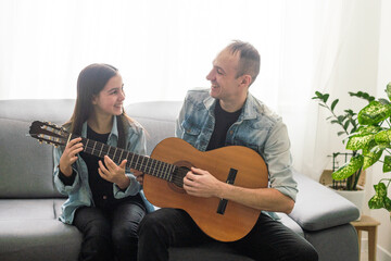 Happy family Father and daughter playing guitar. Father's day.